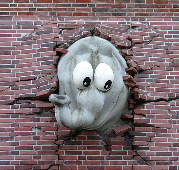 Ein Elefant in einem Comic-Stil durchbricht eine Backsteinwand.