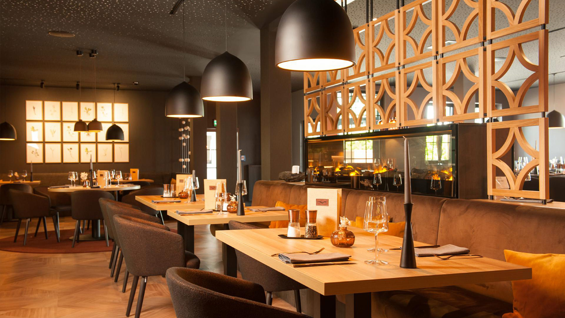 Restaurant mit eingedeckten Tischen und einer Feuerstelle.