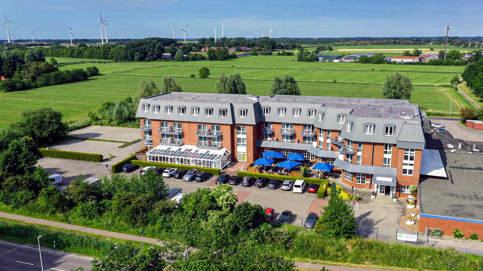 Außenansicht des Hotels Novum mit großen Wiesenflächen im Hintergrund.