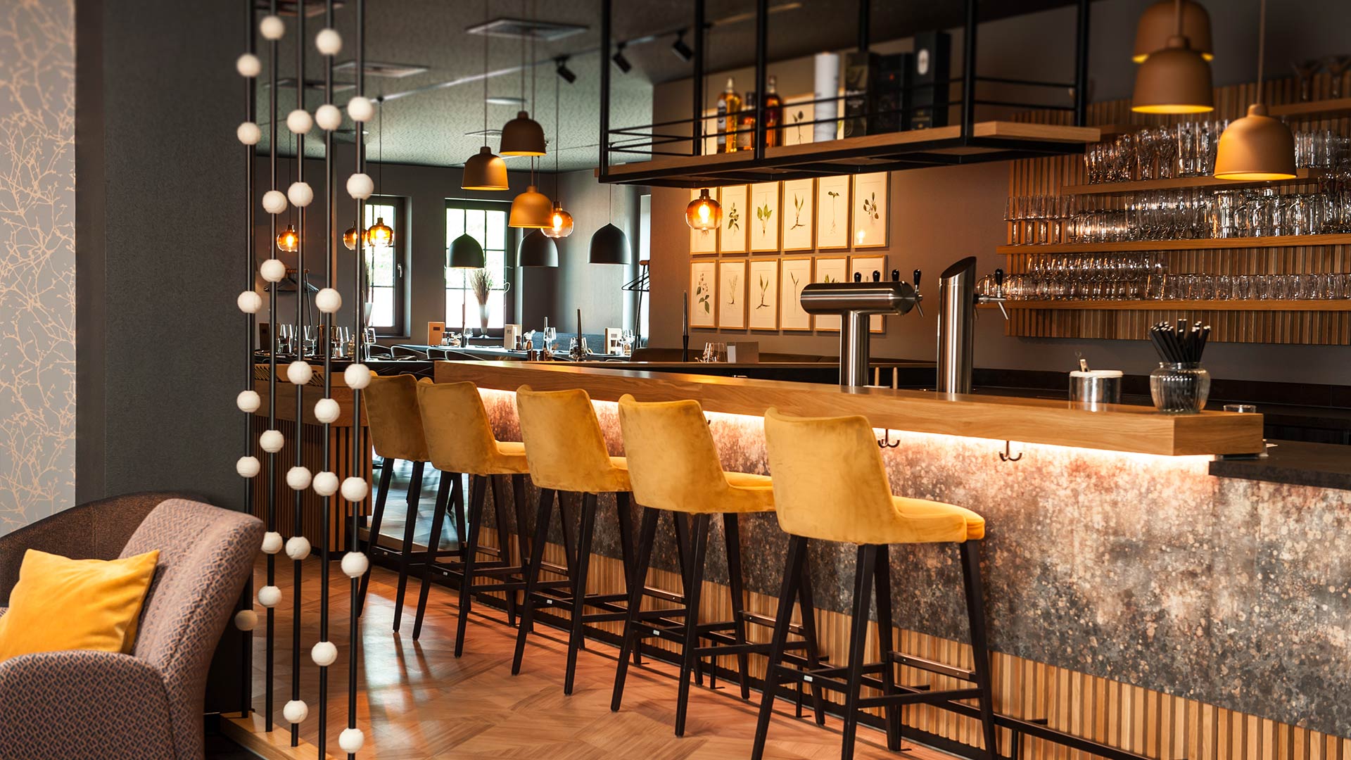 Bar mit Barhockern und einem Restaurant im Hintergrund.