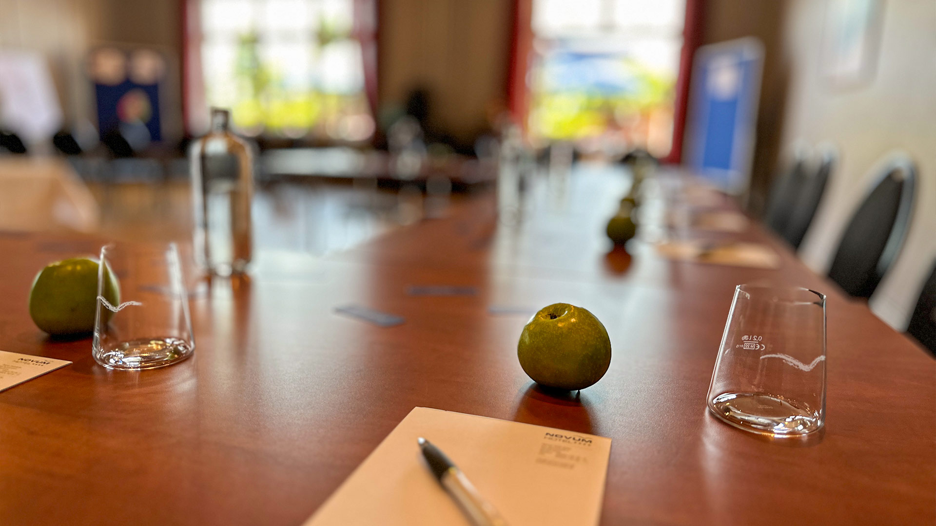 Nahaufnahme von einem Apfel und einem Glas auf einem Tisch.