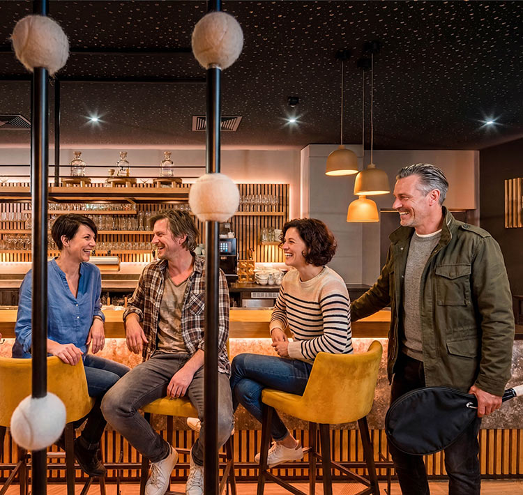 Gruppe Menschen sitzt lachend an einer Bar-Theke