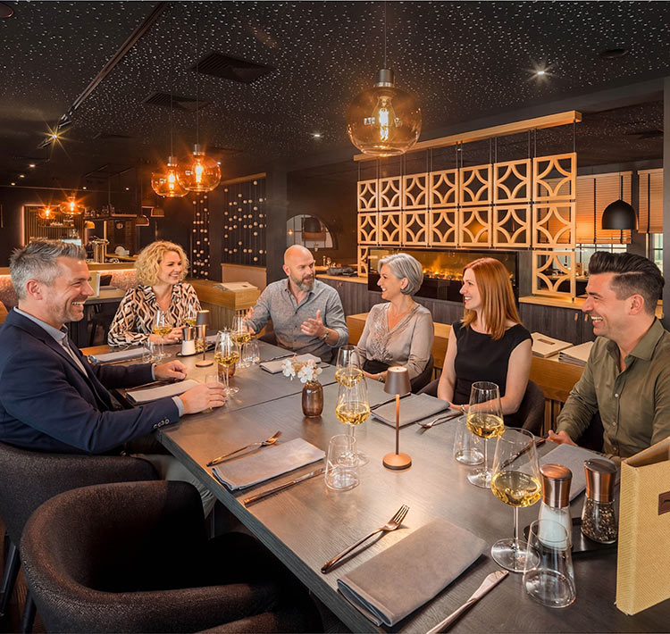 Eine Gruppe Menschen sitzt zusammen am Tisch im Restaurant