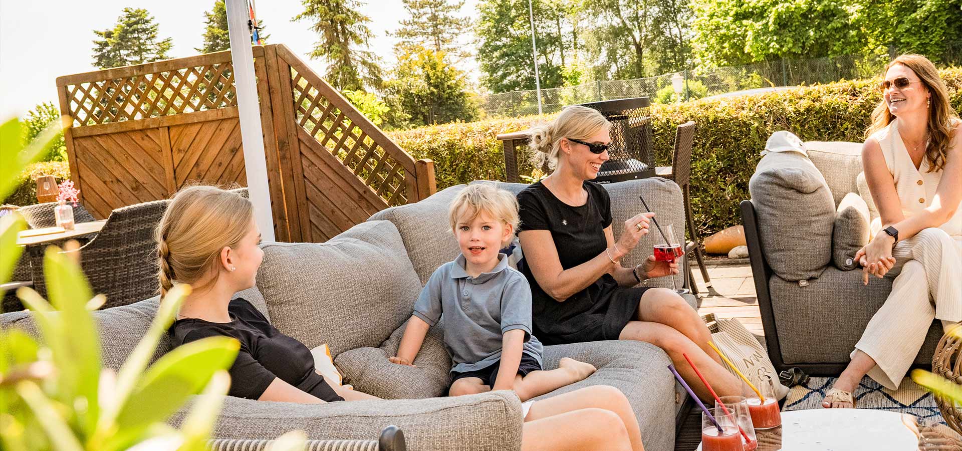 Frauen und Kinder sitzen auf Sofas in der Sonne